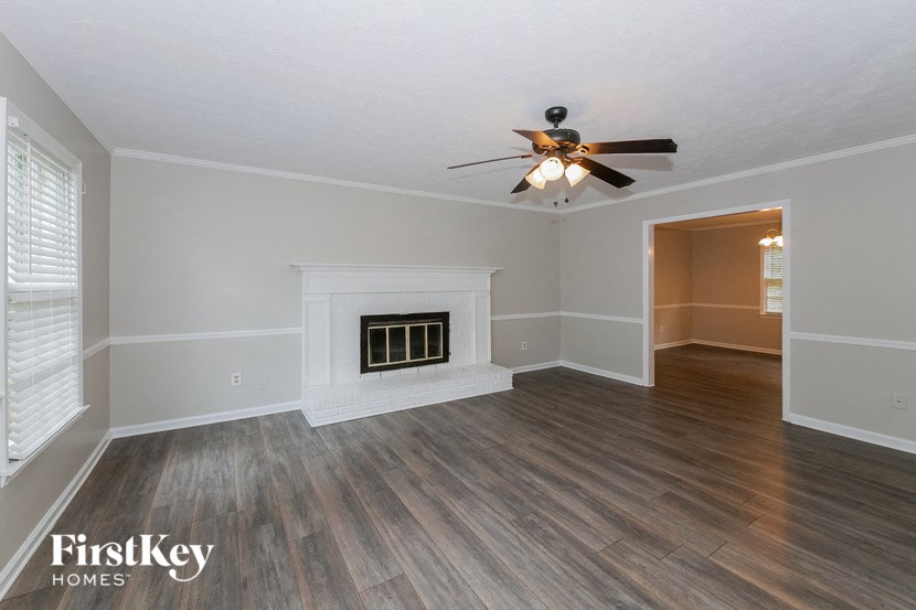 a living room with a ceiling fan and a fireplace