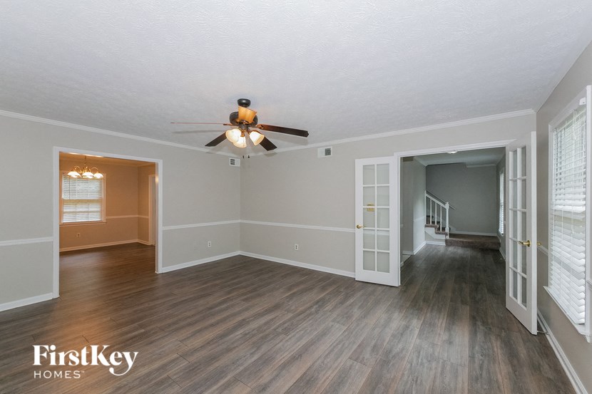 the living room of an empty house with a ceiling fan