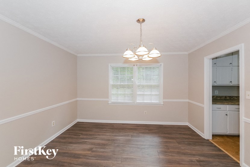 a dining room with wood floors and a window and a chandelier