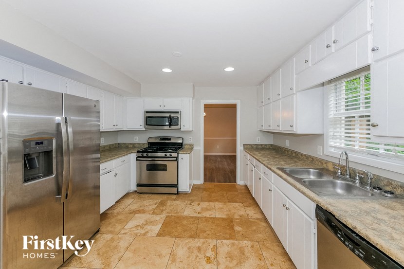 a white kitchen with stainless steel appliances and white cabinets