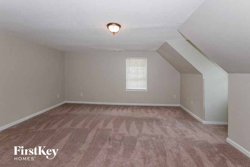 the loft in this home has a vaulted ceiling and hardwood floors