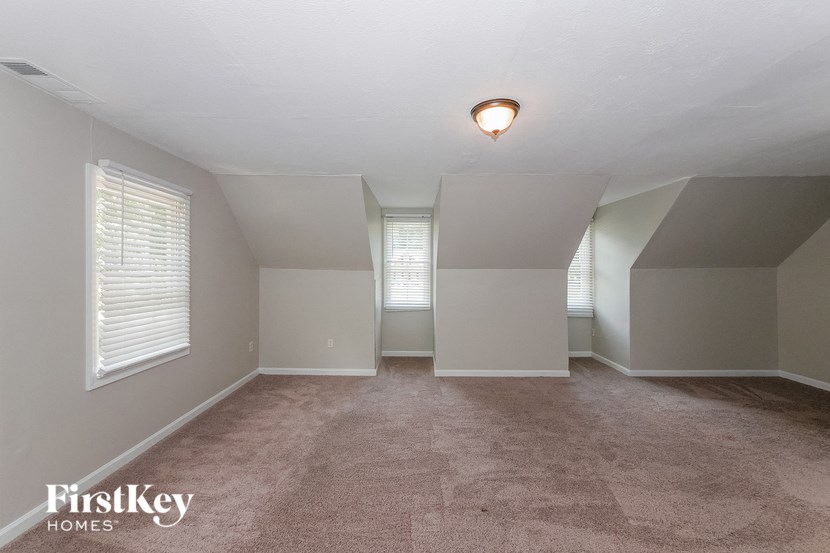 the spacious living room with vaulted ceilings and windows