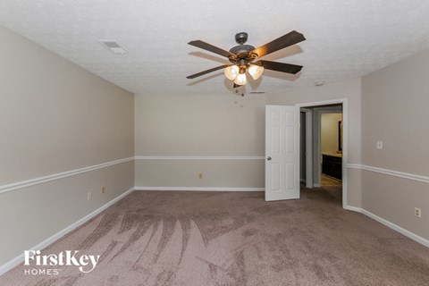 a living room with carpet and a ceiling fan