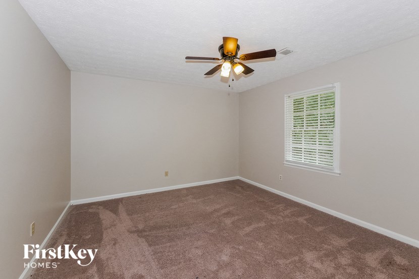 a bedroom with carpet and a ceiling fan