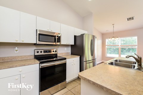 a kitchen with white cabinets and stainless steel appliances