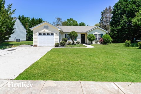 a white house with a lawn and a white garage door