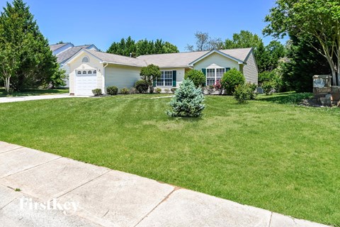 a home with a lawn and a small tree in front of it