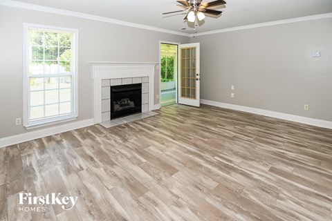 the living room of a home with a fireplace and wooden floors