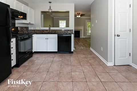 a kitchen with black appliances and white cabinets