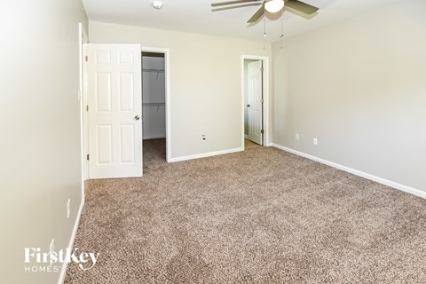 a bedroom with a carpeted floor and a ceiling fan