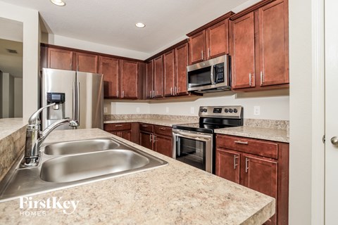 A kitchen with brown cabinets and a granite countertop.