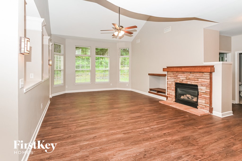 a living room with a fireplace and a ceiling fan