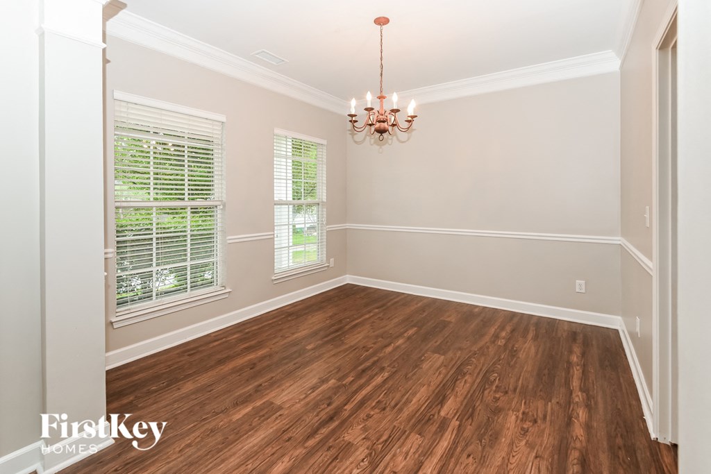 a dining room with wood floors and a chandelier