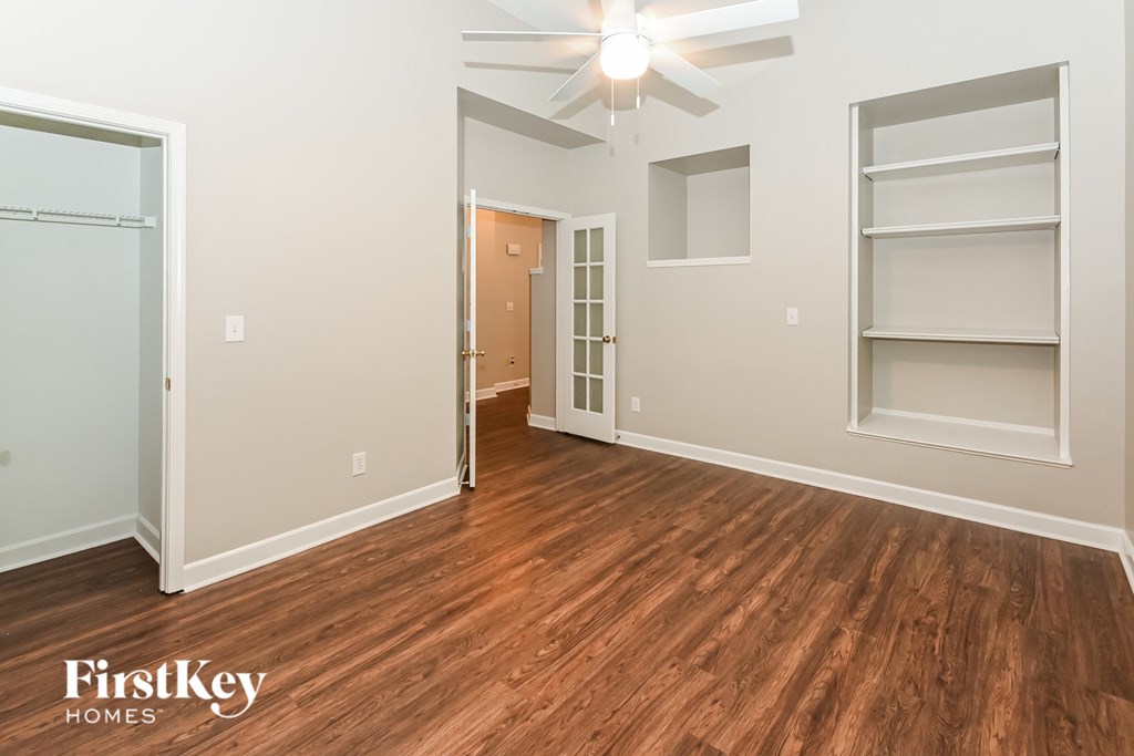 a living room with hardwood flooring and a ceiling fan