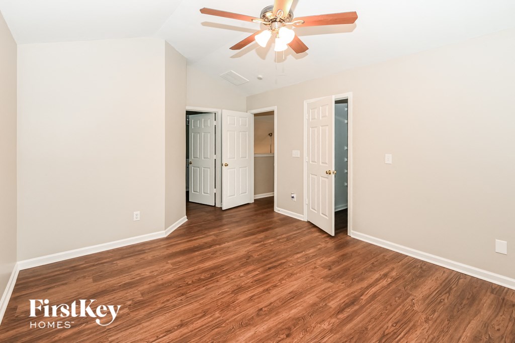 a living room with wood floors and a ceiling fan