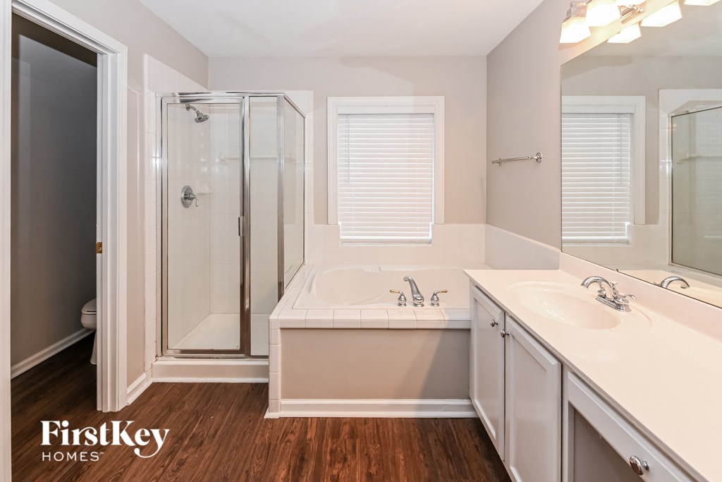 a bathroom with a tub and a shower and a sink