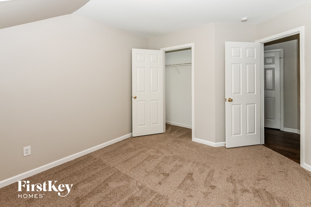 a bedroom with two closets and a carpeted floor