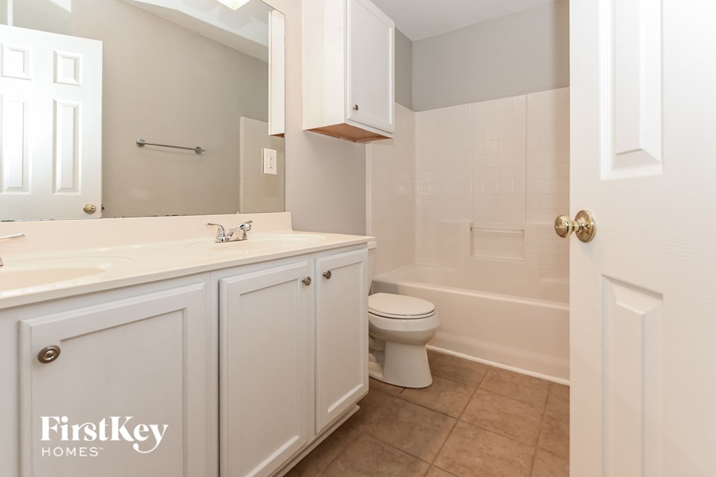 a white bathroom with a toilet and a sink