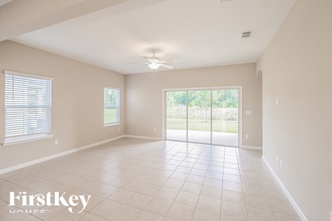 A spacious room with a sliding glass door leading to a garden.