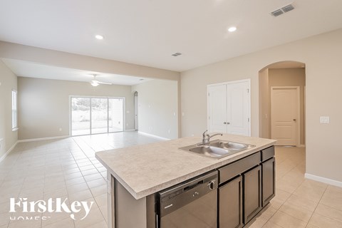 A kitchen with a sink and cabinets in a house.