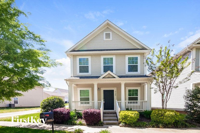 A two-story house with a front porch and a mailbox.