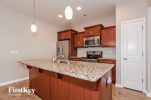 A kitchen with brown cabinets and granite countertops.