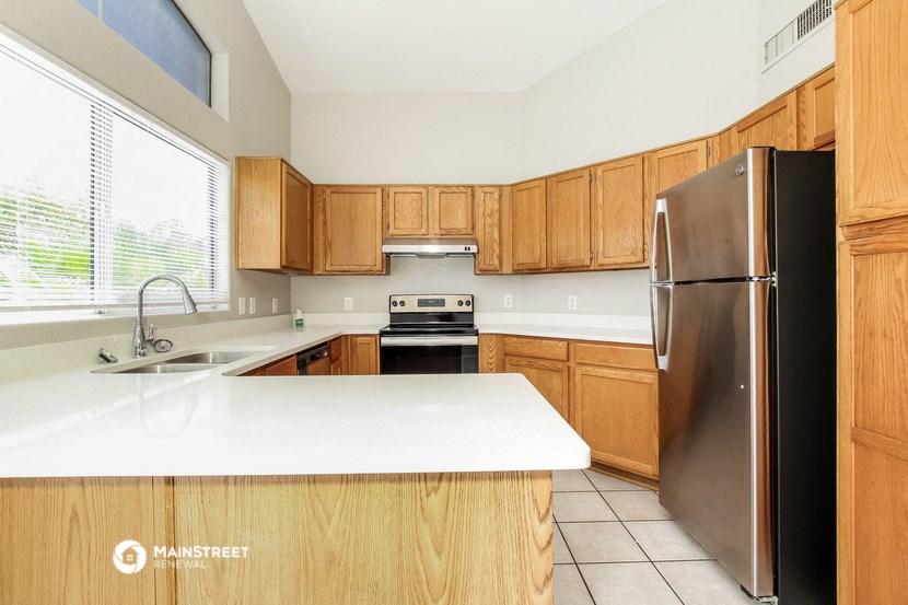 a kitchen with wooden cabinets and a stainless steel refrigerator