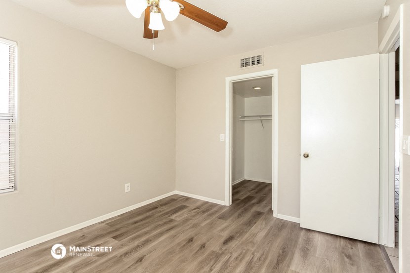 a bedroom with a closet and a ceiling fan