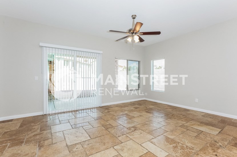a living room with tile floors and a ceiling fan