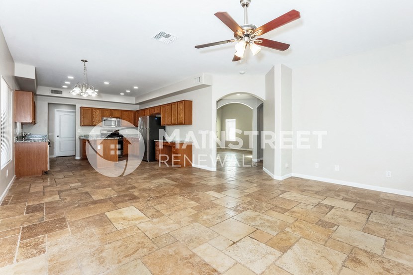 a kitchen and living room with tile flooring and a ceiling fan