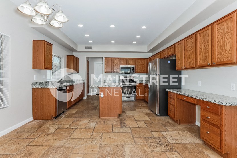 a kitchen with wooden cabinets and a stainless steel refrigerator