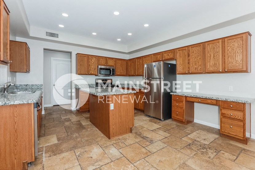 a kitchen with wooden cabinets and a stainless steel refrigerator