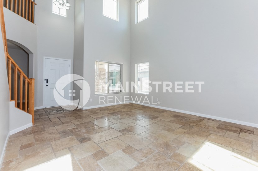 a renovated house with a large living room and travertine floors