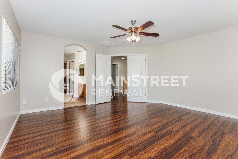 a living room with hardwood floors and a ceiling fan