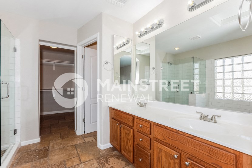 two sinks in a bathroom with a large mirror and a shower