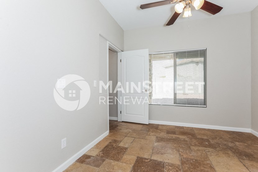 a renovated living room with a ceiling fan and a door to a closet