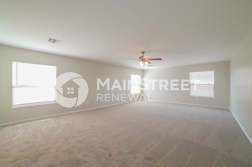 a living room with carpet and a ceiling fan