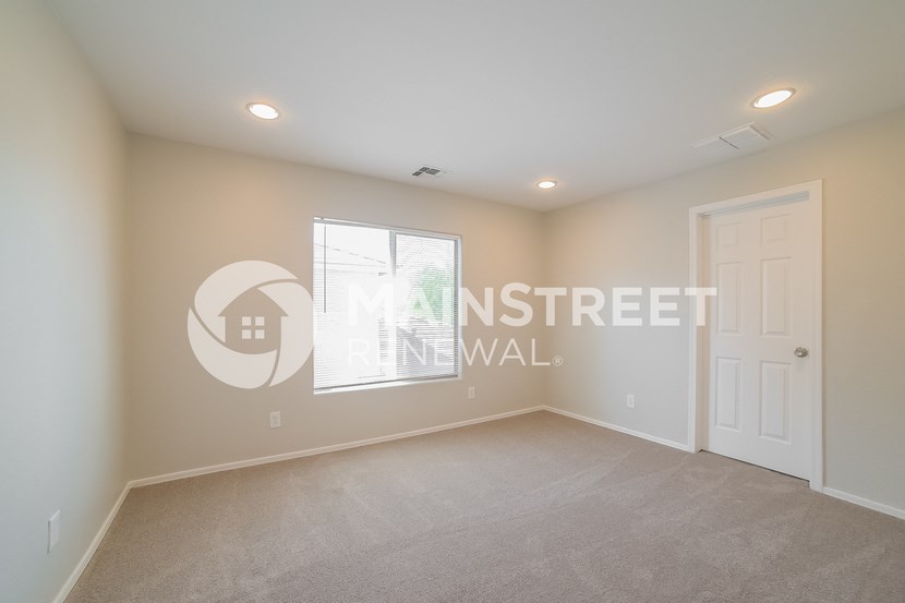 a bedroom with a white wall and a white door