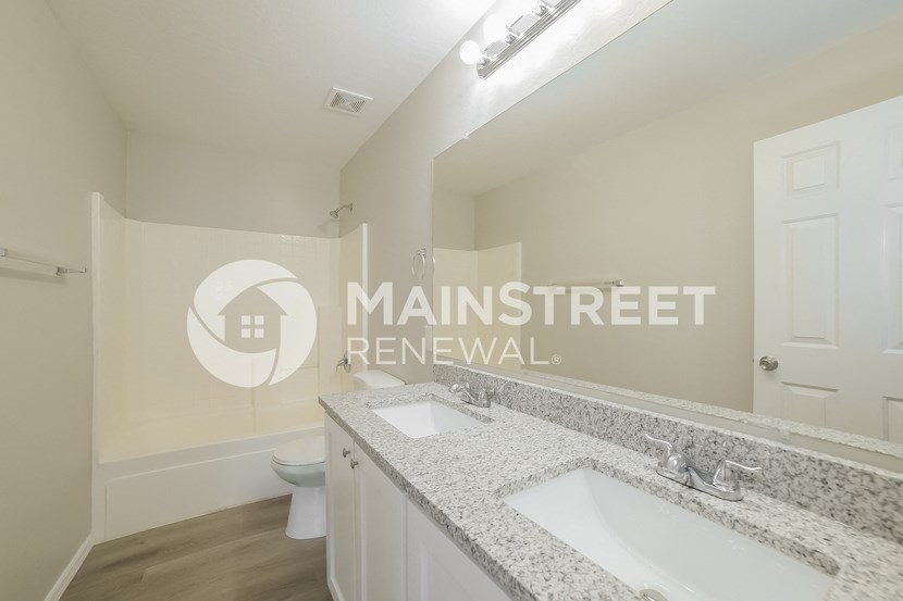 a bathroom with a sink and a toilet and a mirror