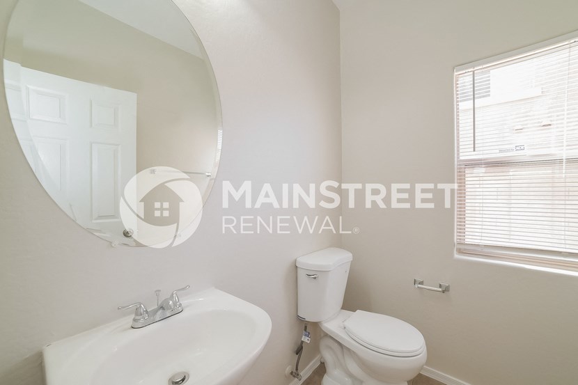 a white bathroom with a sink toilet and a mirror