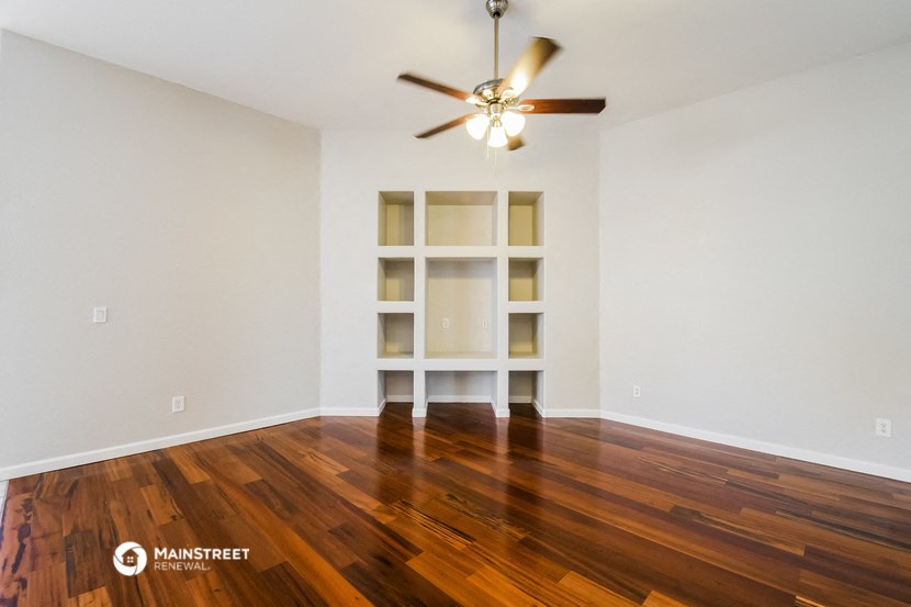the living room with hardwood floors and a ceiling fan