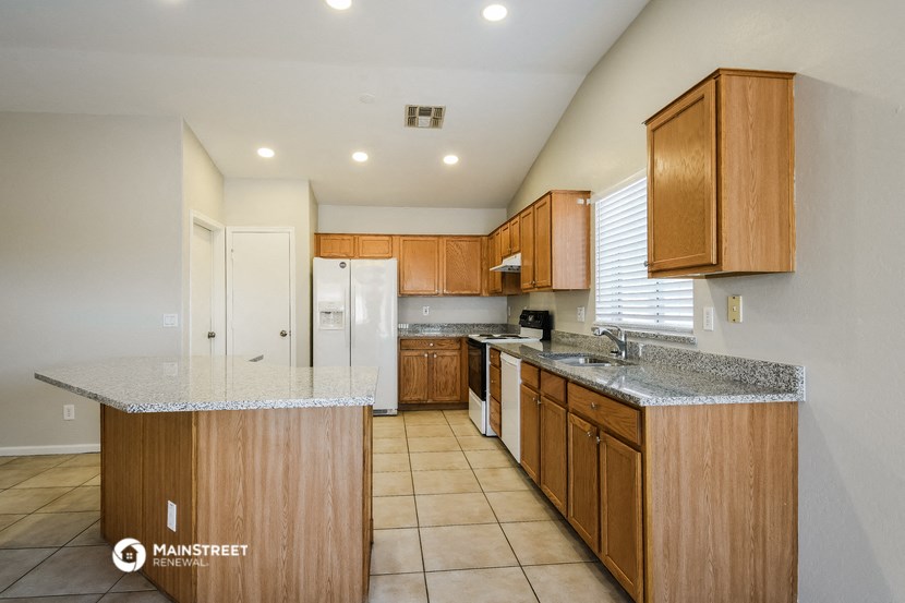 a kitchen with wooden cabinets and granite counter tops