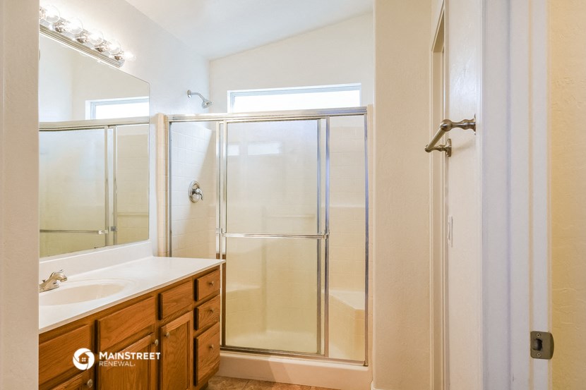 a bathroom with a shower and a sink and a mirror