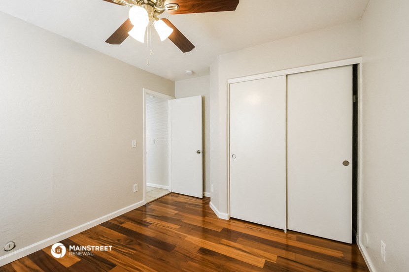 a bedroom with two closets and a ceiling fan