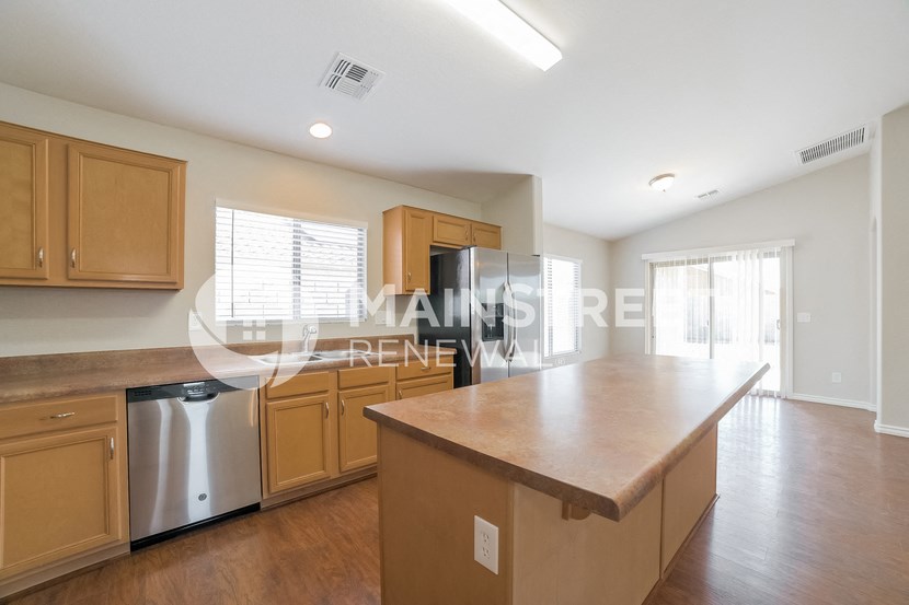 a large kitchen with a large island and wooden cabinets