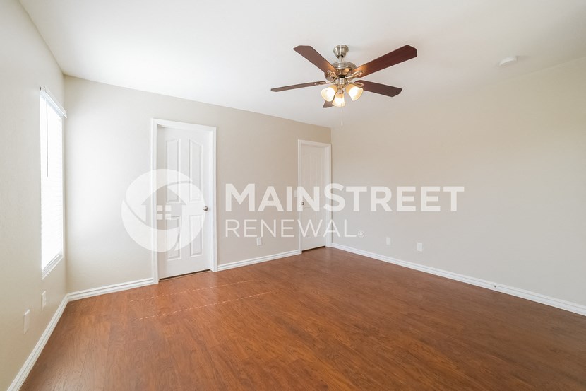 renovated living room with wood flooring and a ceiling fan
