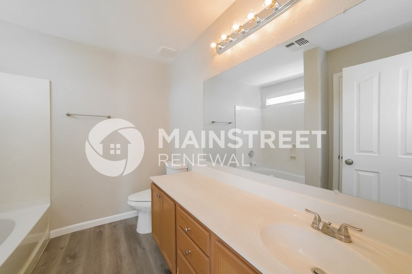 a bathroom with a sink and a toilet and a mirror