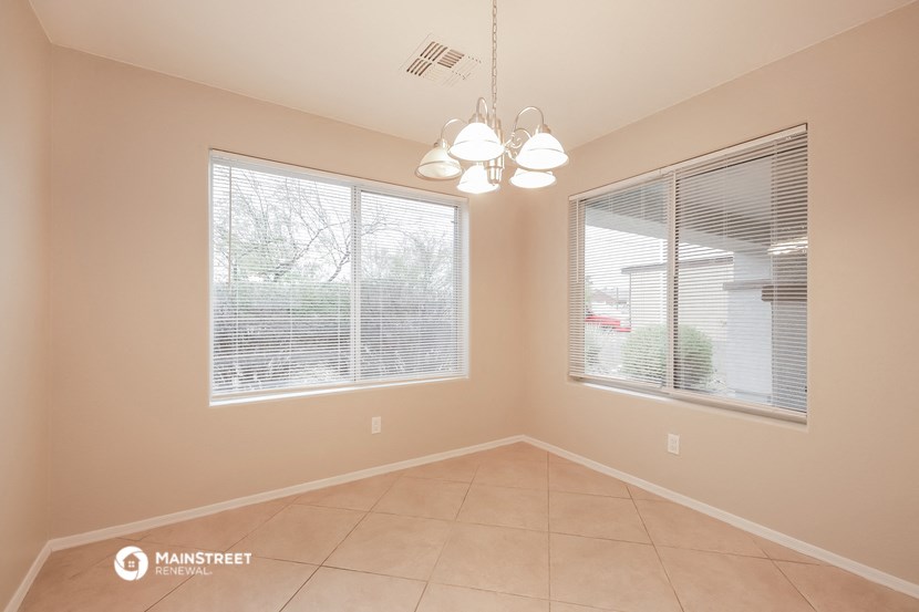 a dining room with two windows and a chandelier