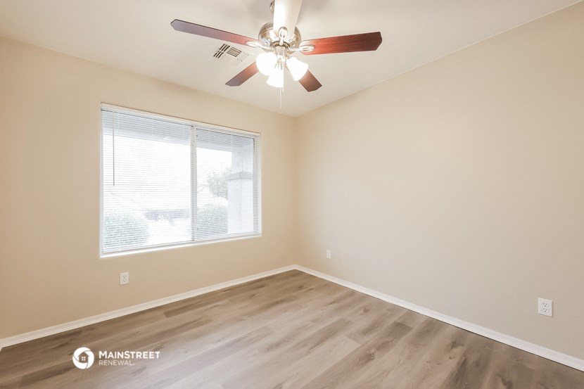 an empty room with a ceiling fan and a window