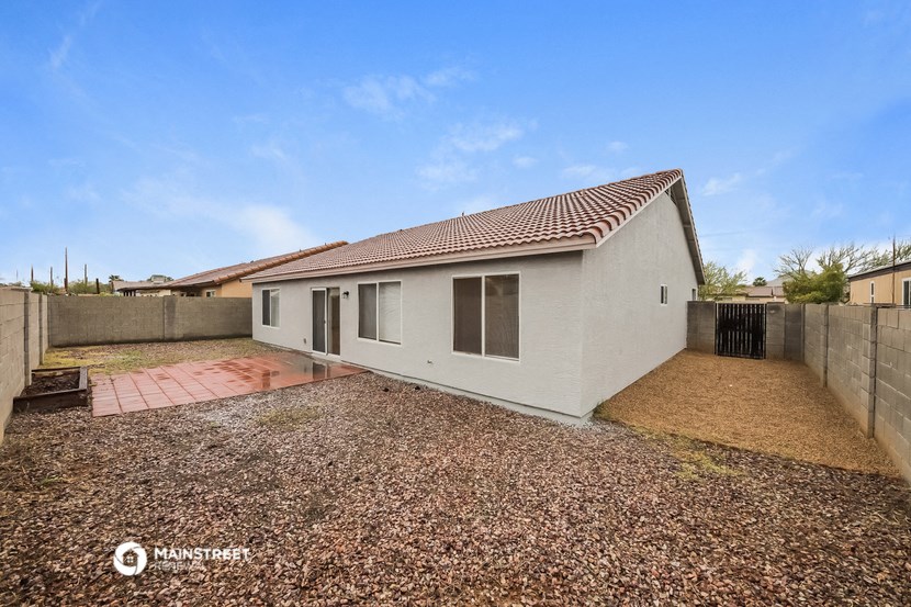 a small white house with a yard and a fence